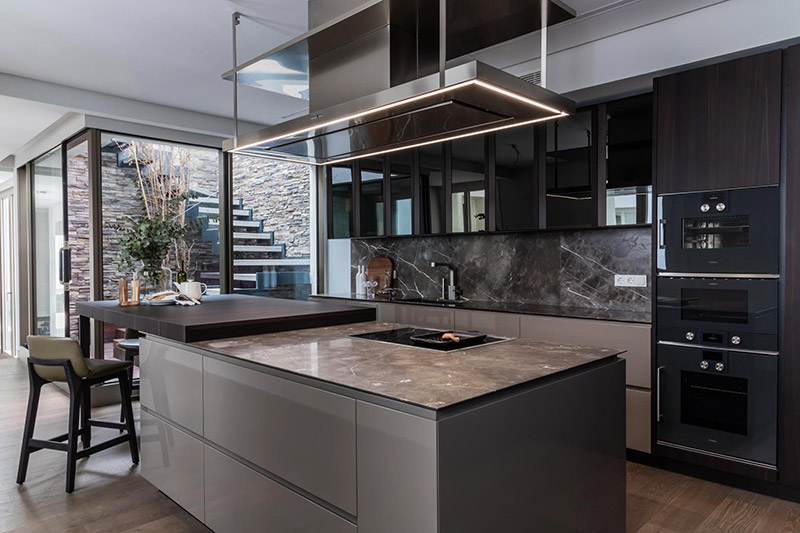 Vista genera de una cocina en tonos oscuros